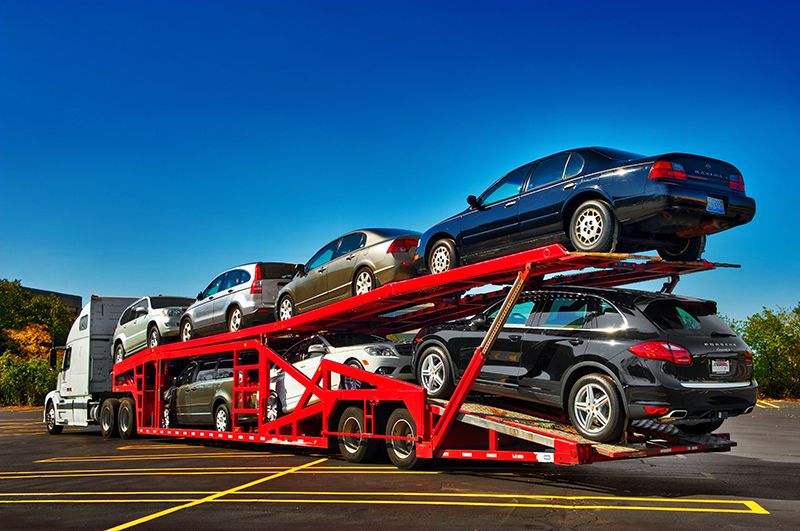 Multiple cars loaded on a carrier, representing full coverage car insurance protection
