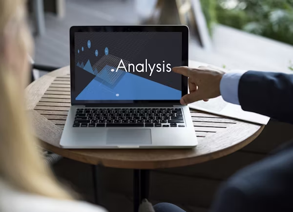 Insurance analyst reviewing credit score auto insurance rates data on a laptop